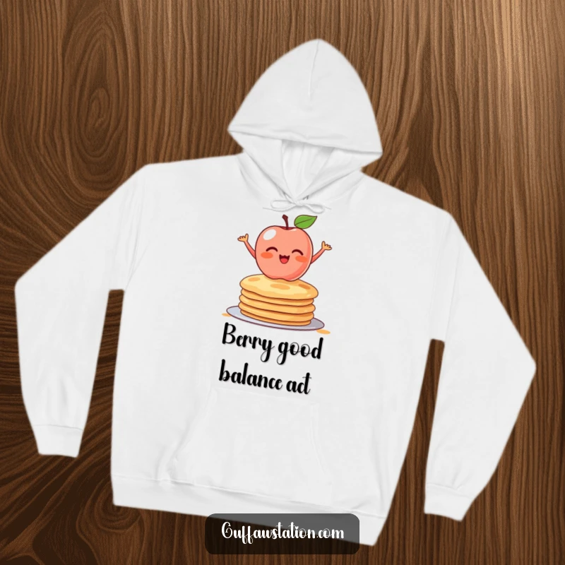 Funny hoodie design showing a shy apple precariously balanced on a stack of pancakes. Cozy and comical apparel for food lovers.